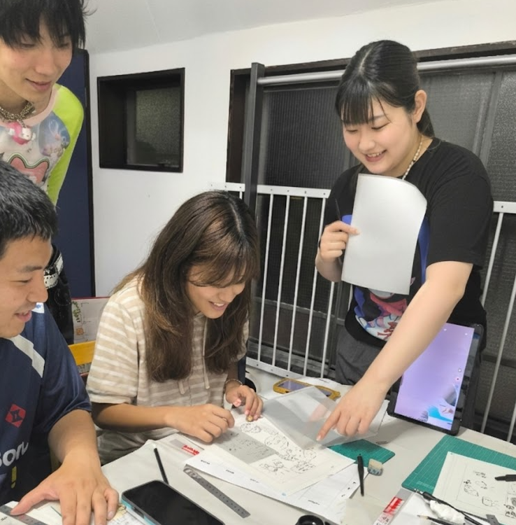 Guests proudly showing their completed manga artwork